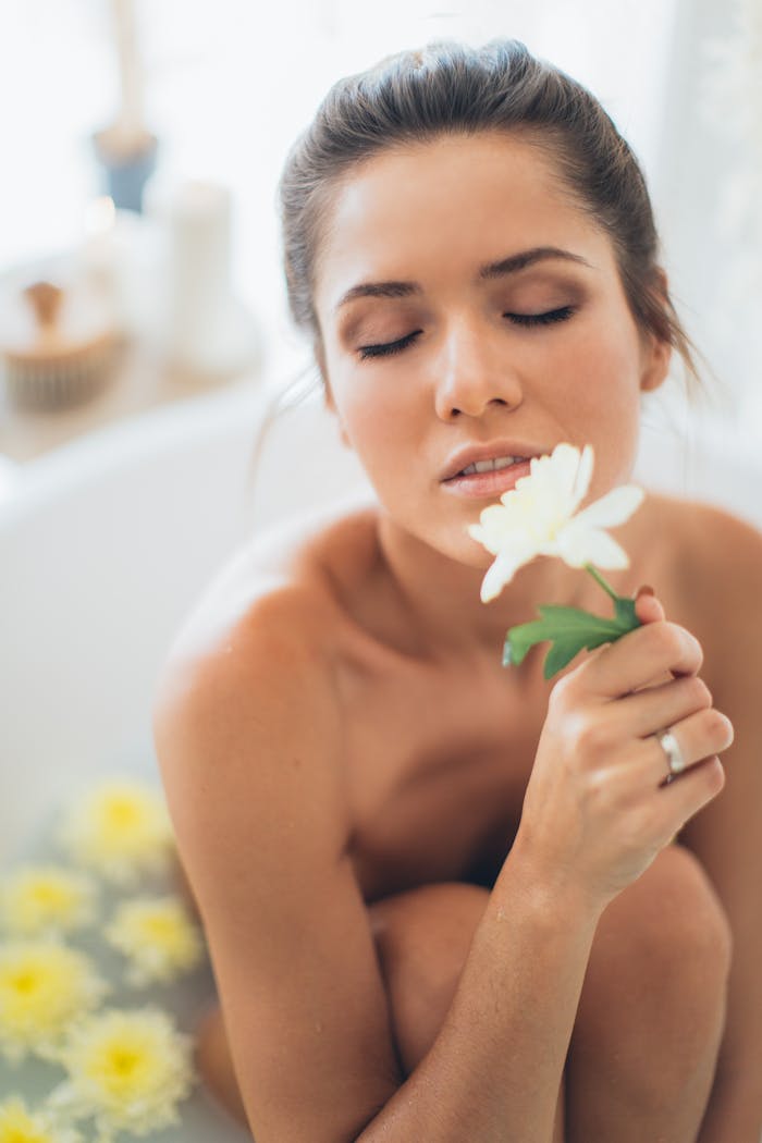 A woman enjoying a relaxing spa bath, surrounded by white flowers, embracing tranquility and self-care.